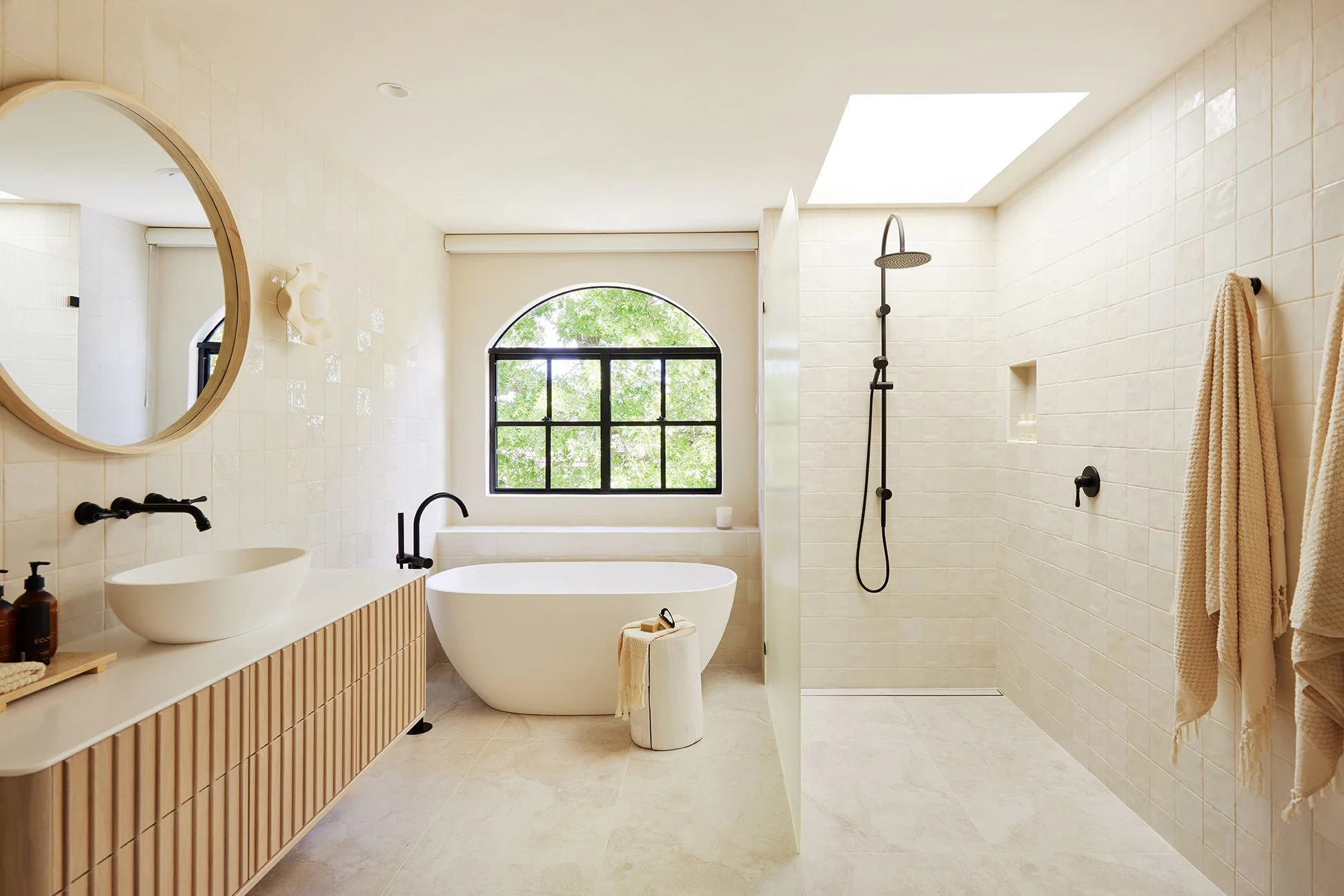 Elegant bathroom renovation with freestanding tub and floor-to-ceiling tile